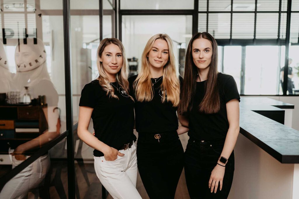 Kristina Sterzer, Lucy-Ann Polak und Anna Vdovenko stehen am Empfang der Physiotherapie Hanseviertel in Lüneburg